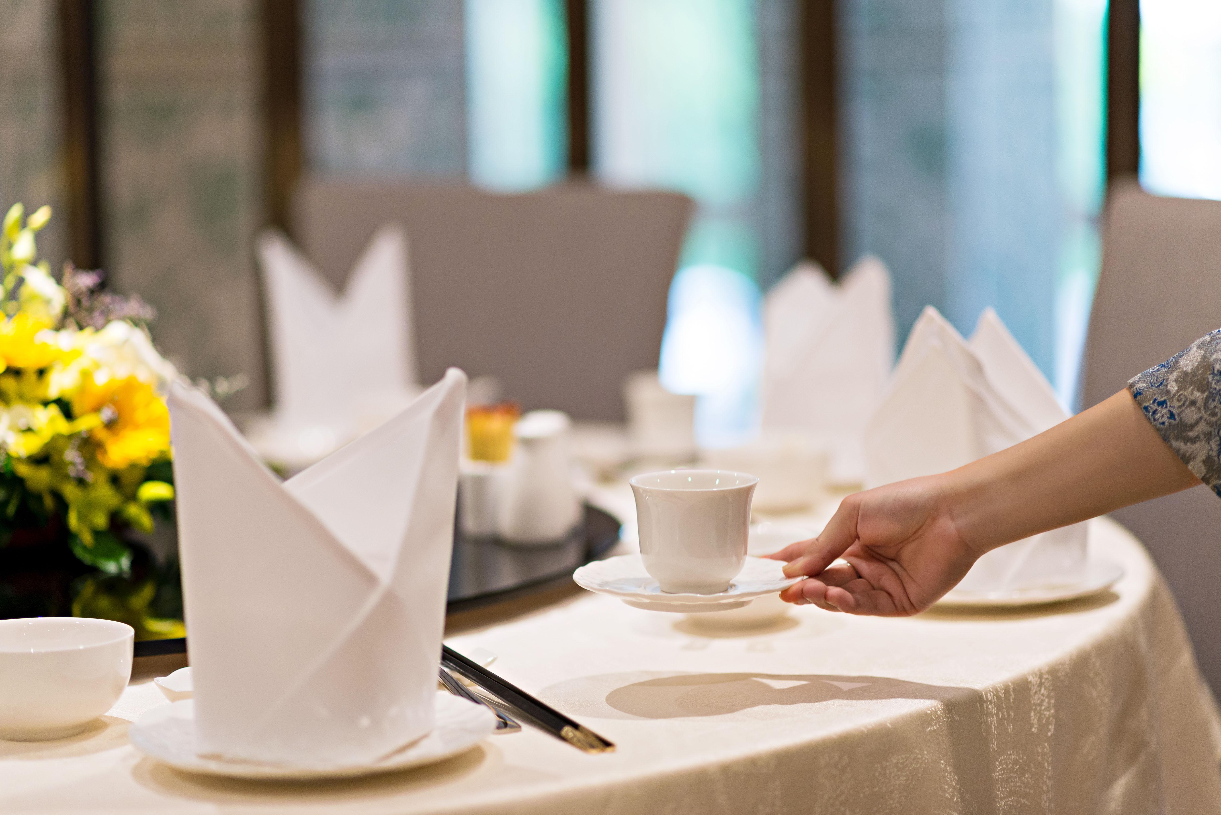 הו צ'י מין סיטי Eastin Grand Hotel Saigon מראה חיצוני תמונה A server sets a table at a restaurant.